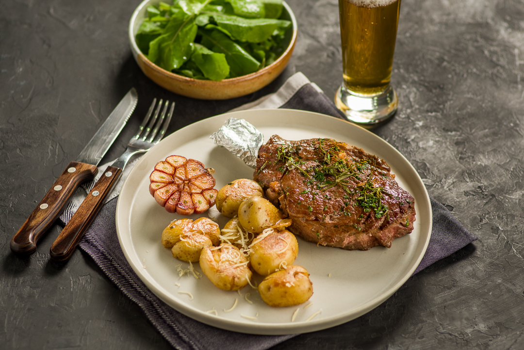 Aprenda a hacer Prime Rib asado con hierbas y papas al horno con ajo y queso parmesano