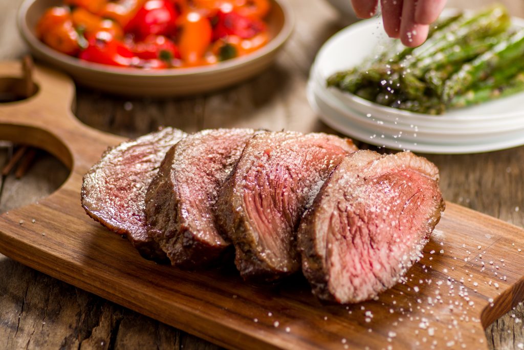 Imagem de picanha grelhada com sal e pimenta de parrilla com mix de mini piemntoes assados e aspargos grelhados no azeite, com parmesão e lascas de amêndoas.