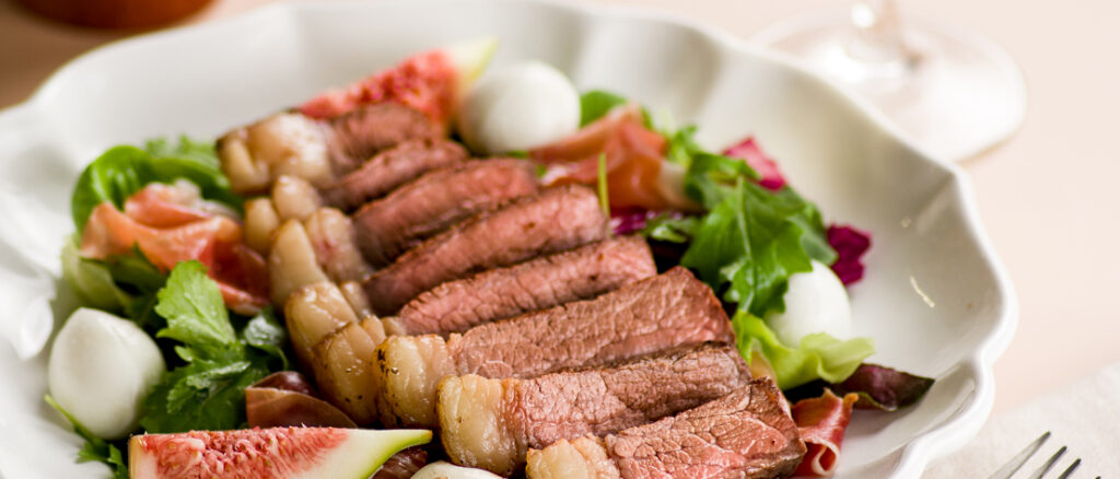 Imagem de picanha assada com dry rub e acompanhada de salada de figo, parma e búfala.